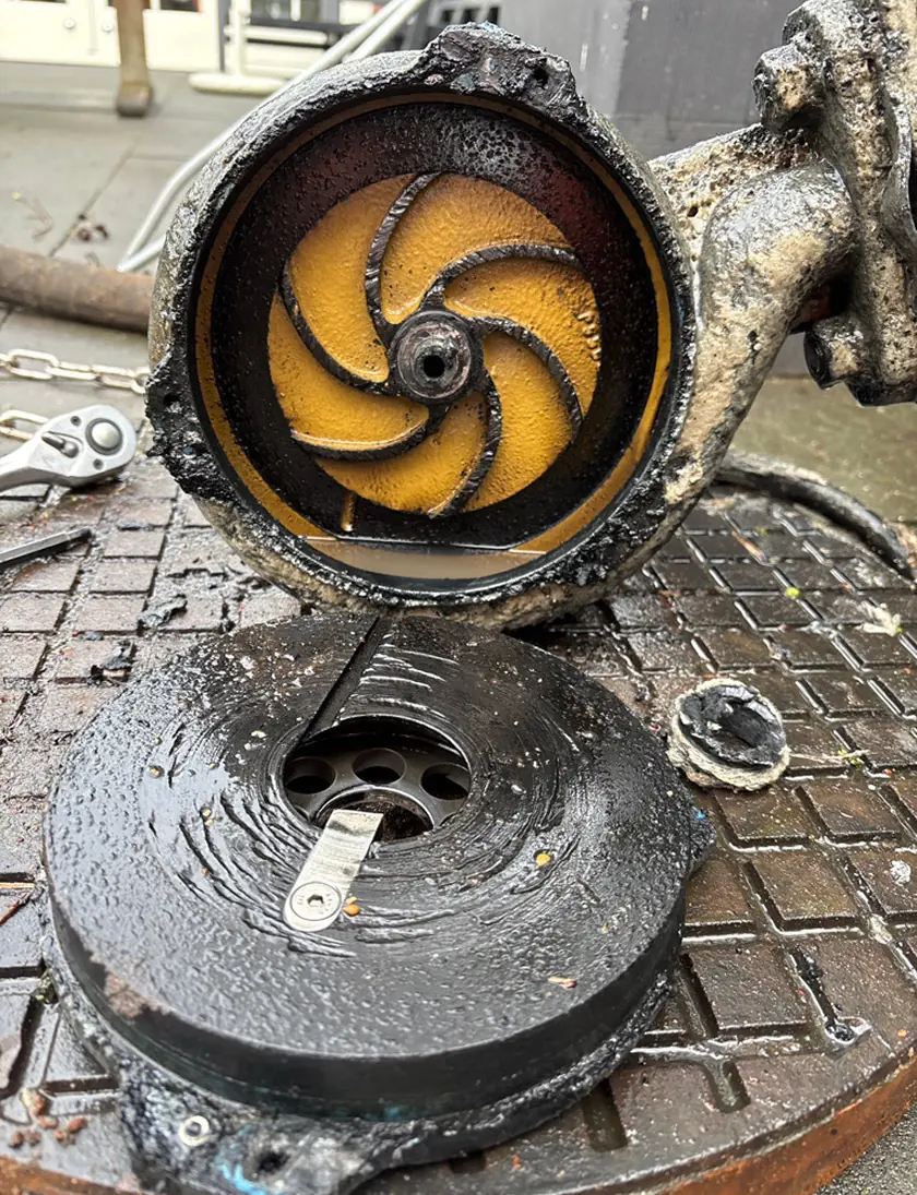 Close-up van een opengesneden gemaalonderdeel met zichtbare binnenmechanismen op een metalen rooster.