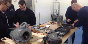 Technici volgen een beheerders-training met apparatuur en gereedschap op een werkbank.