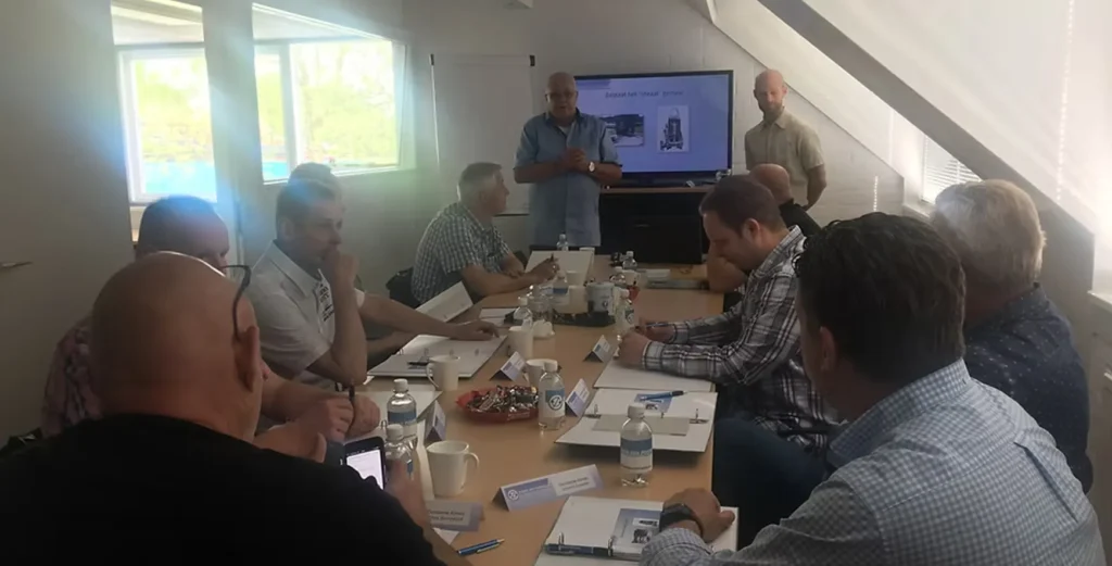 Een groep mensen volgt een presentatie tijdens een training voor beheerders in een vergaderruimte.
