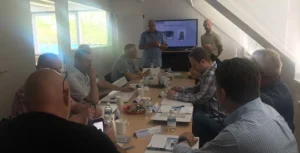 Een groep mensen volgt een presentatie tijdens een training voor beheerders in een vergaderruimte.